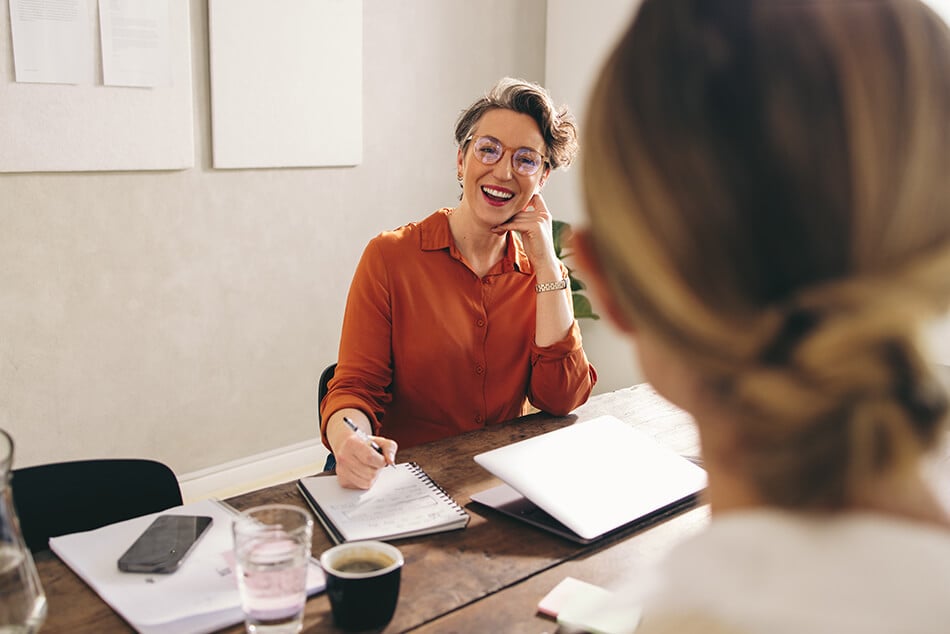 Woman smiling as she sits at her desk